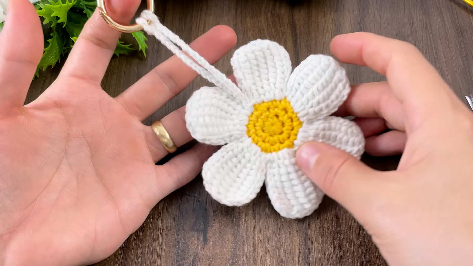 Crochet daisy keychain close-up with soft yarn texture